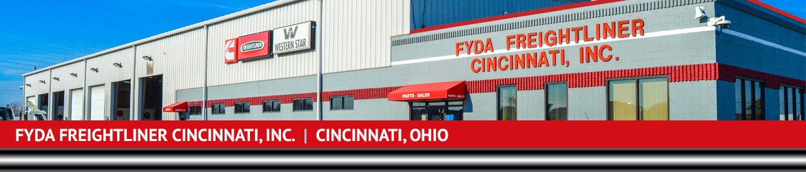 Front of Fyda Freightliner Cincinnati, Inc.with a row of Western Star & Freightliner semi trucks …