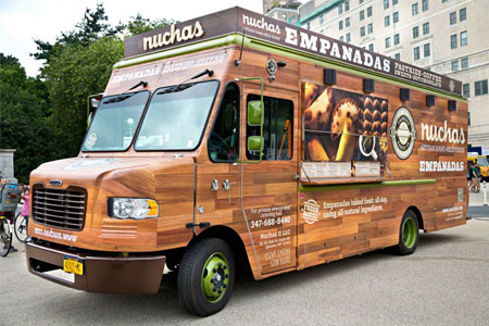 Custom Nuchas food truck parked on the pavement in an urban area.