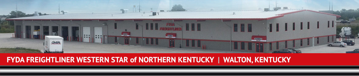 Wide-shot of Fyda Freightliner building and warehouse with cars parked in the parking lot.